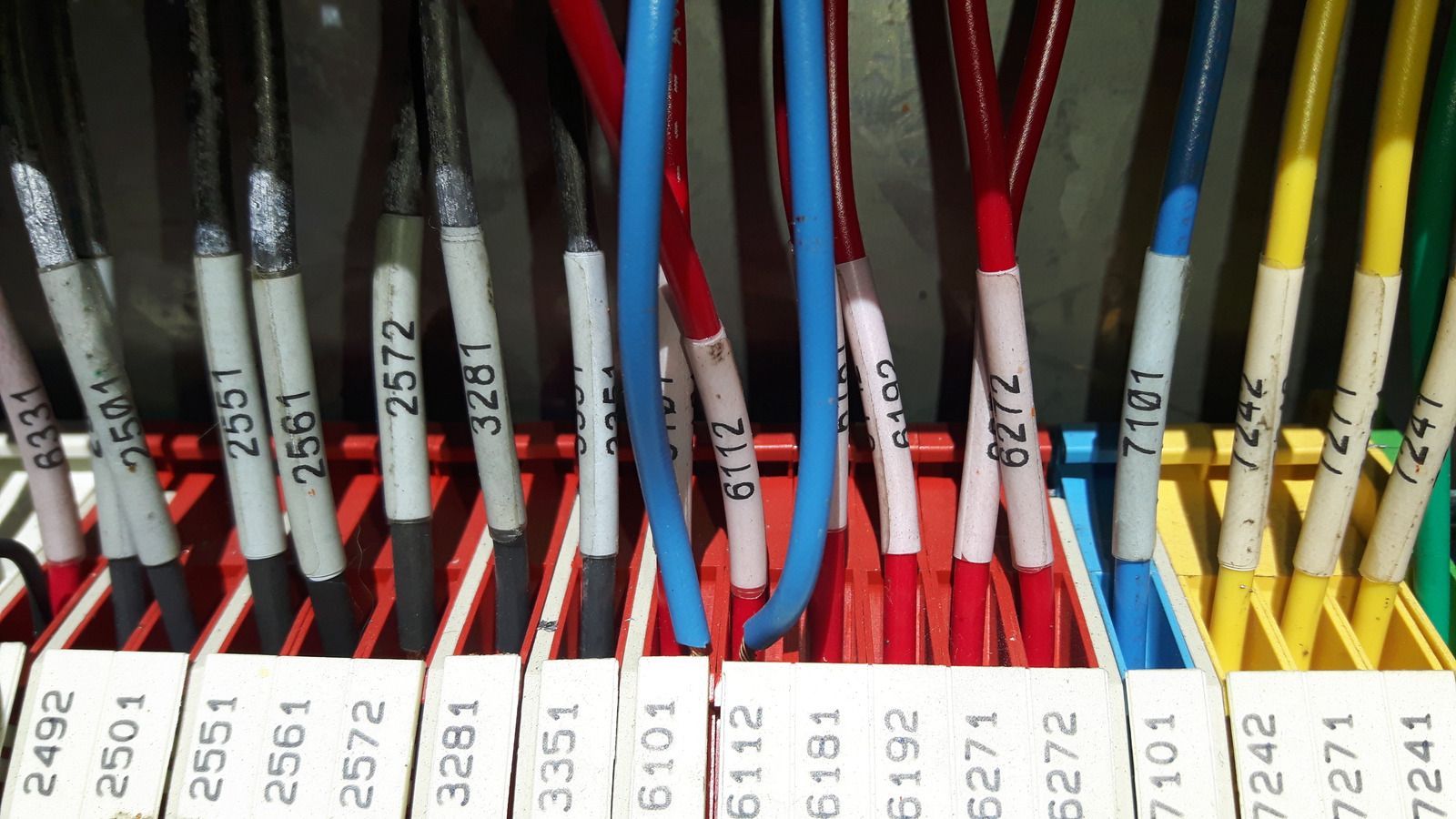 Close-up of electrical wires with numbered labels in a panel, showing a variety of colored wires.
