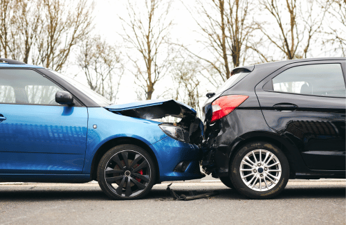 Blue and black cars with front-end collision on a road, with visible damage to both vehicles.