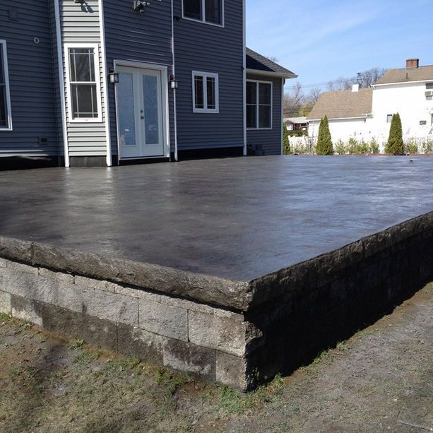 A large concrete deck in front of a house