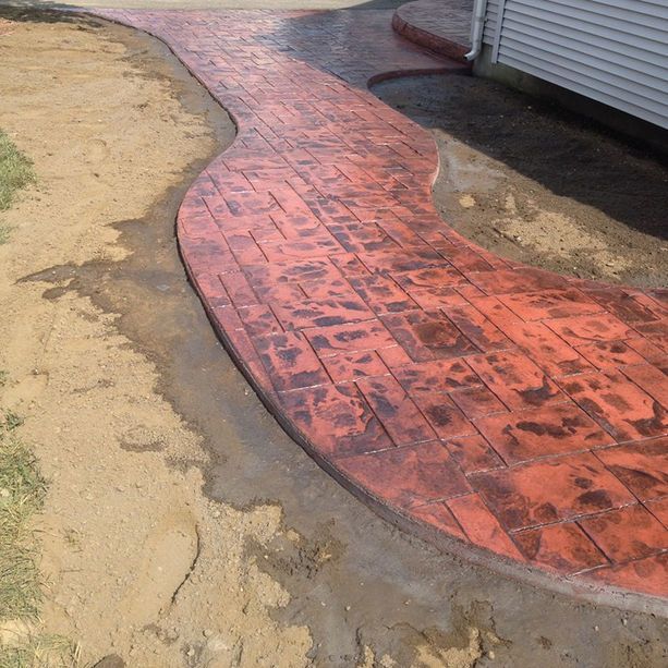 A brick walkway is being built in front of a house.