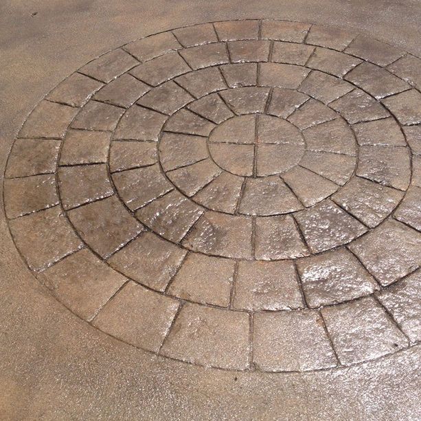 A circular pattern of bricks on a concrete surface