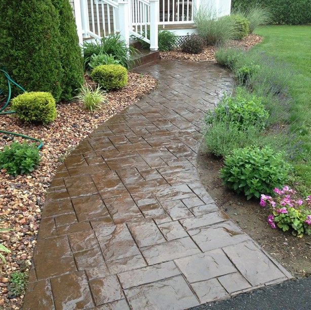 A brick walkway leading to a white house