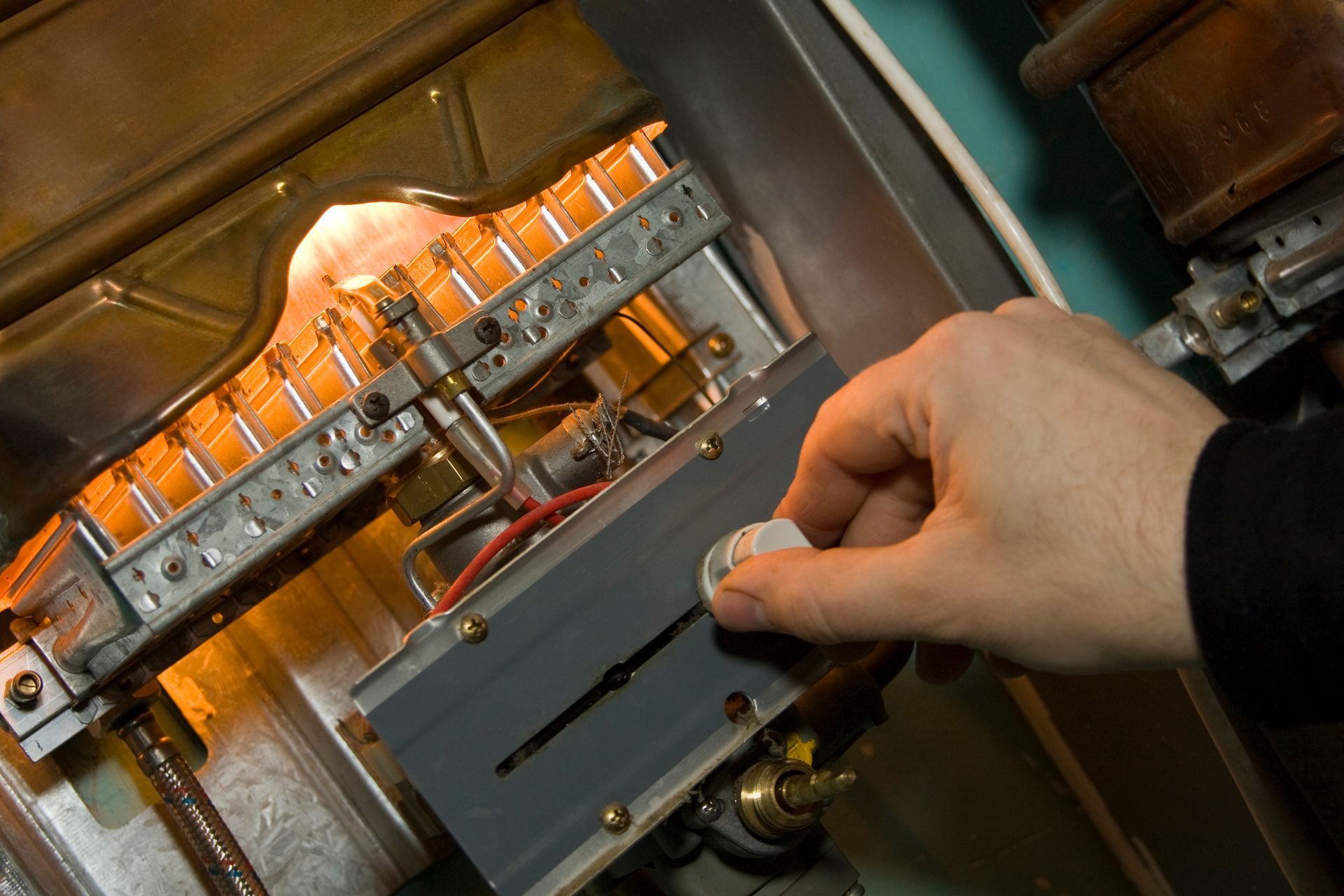 Hand turning a knob on an electrical control panel with orange indicator lights.