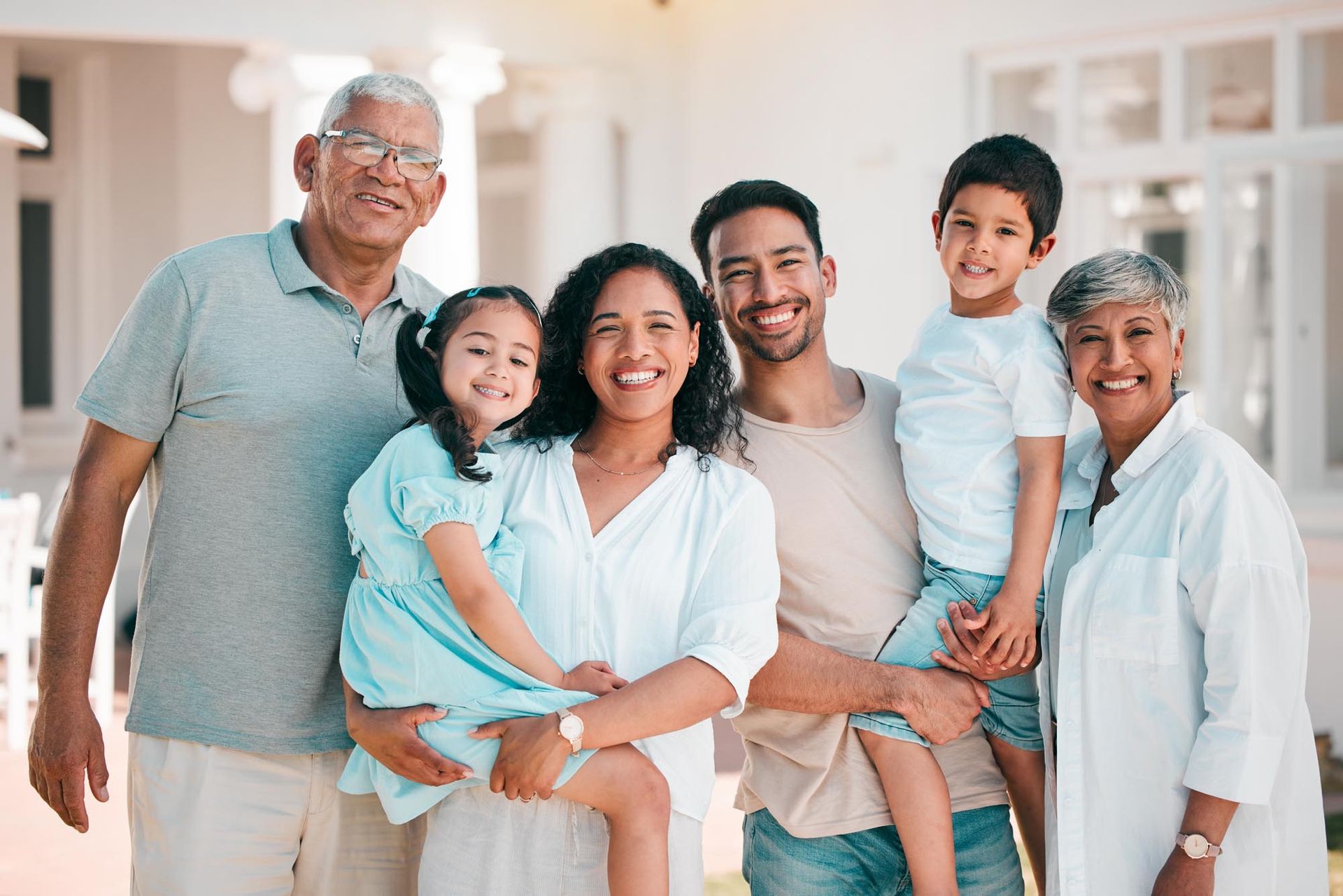 Smiling family of six standing together in a bright home hallway