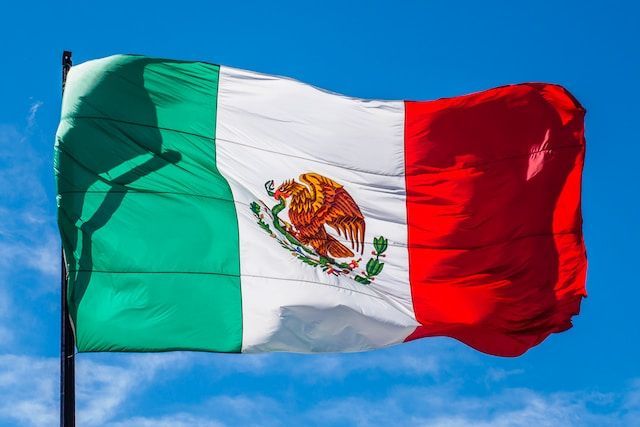 Mexican flag waving against a blue sky