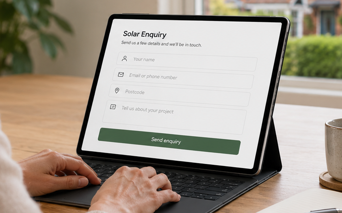 Hands typing on a laptop showing a solar enquiry form on screen.