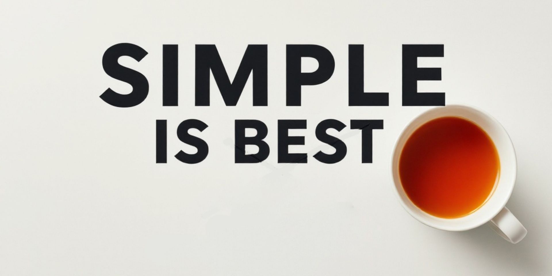 A cup of tea is on a table next to a sign that says simple is best.