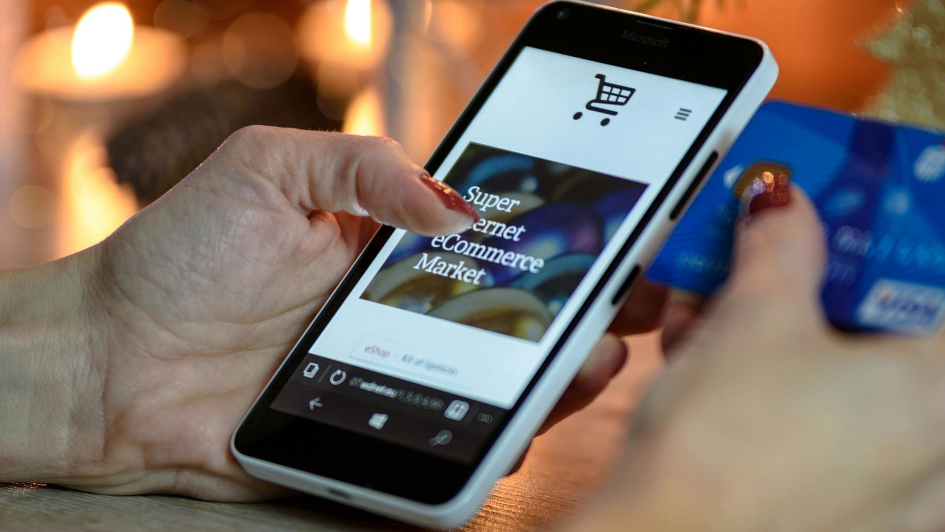 A person is holding a cell phone and a credit card.