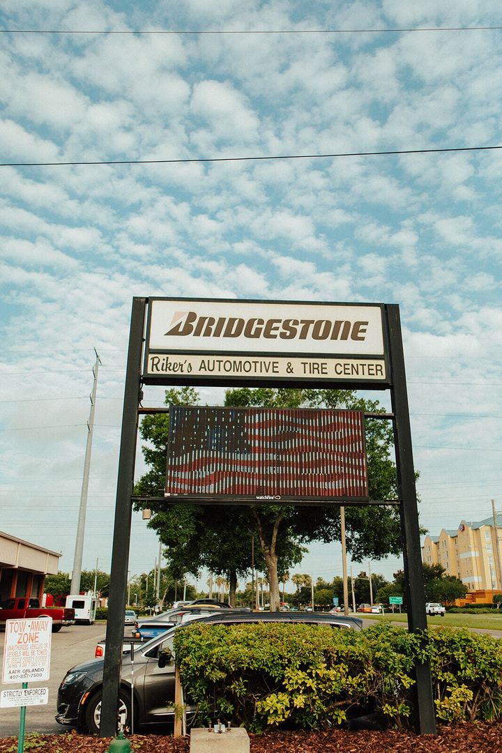 Bridgestone sign at a tire shop, with an obscured American flag display.