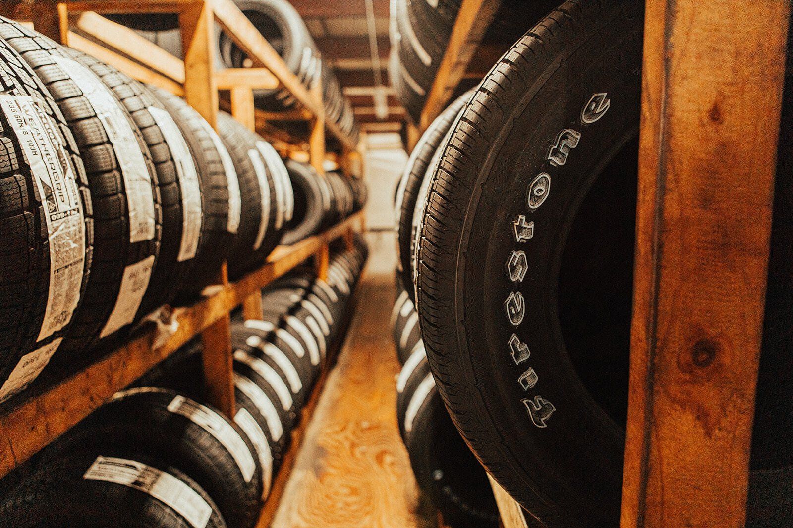 Tires stacked on wooden shelves in a storage room.