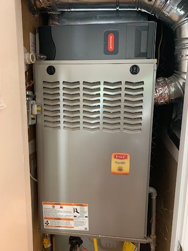 A stainless steel air conditioner is sitting in a closet.