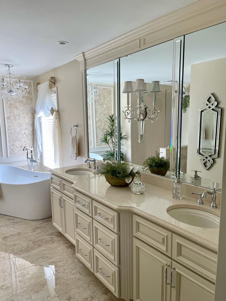 Elegant bathroom with double vanity, large mirrors, bathtub, and marble tile flooring