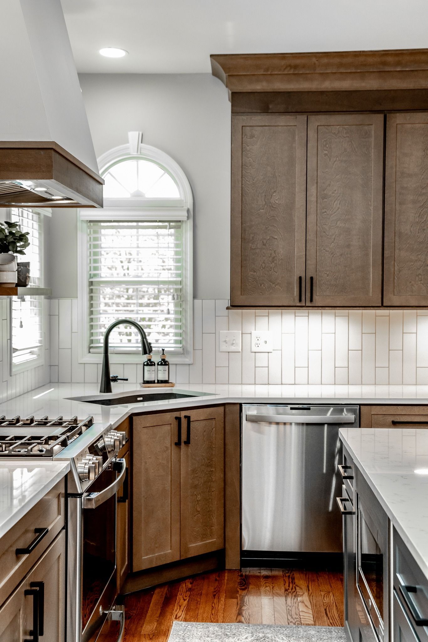 Modern kitchen with wood cabinets, stainless appliances, and a window over the sink