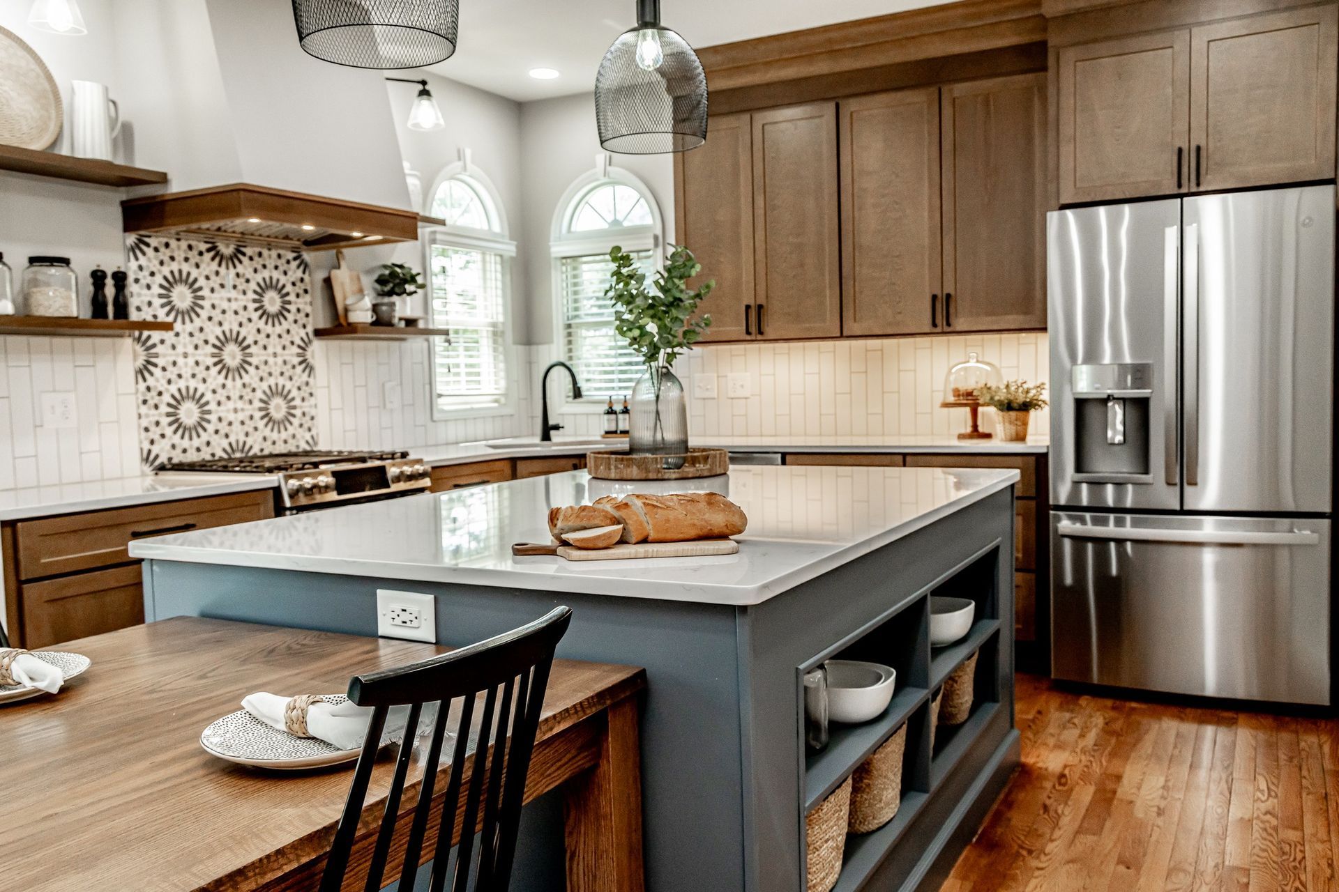 Modern kitchen with large island, stainless steel appliances, wood cabinets, and hardwood floors