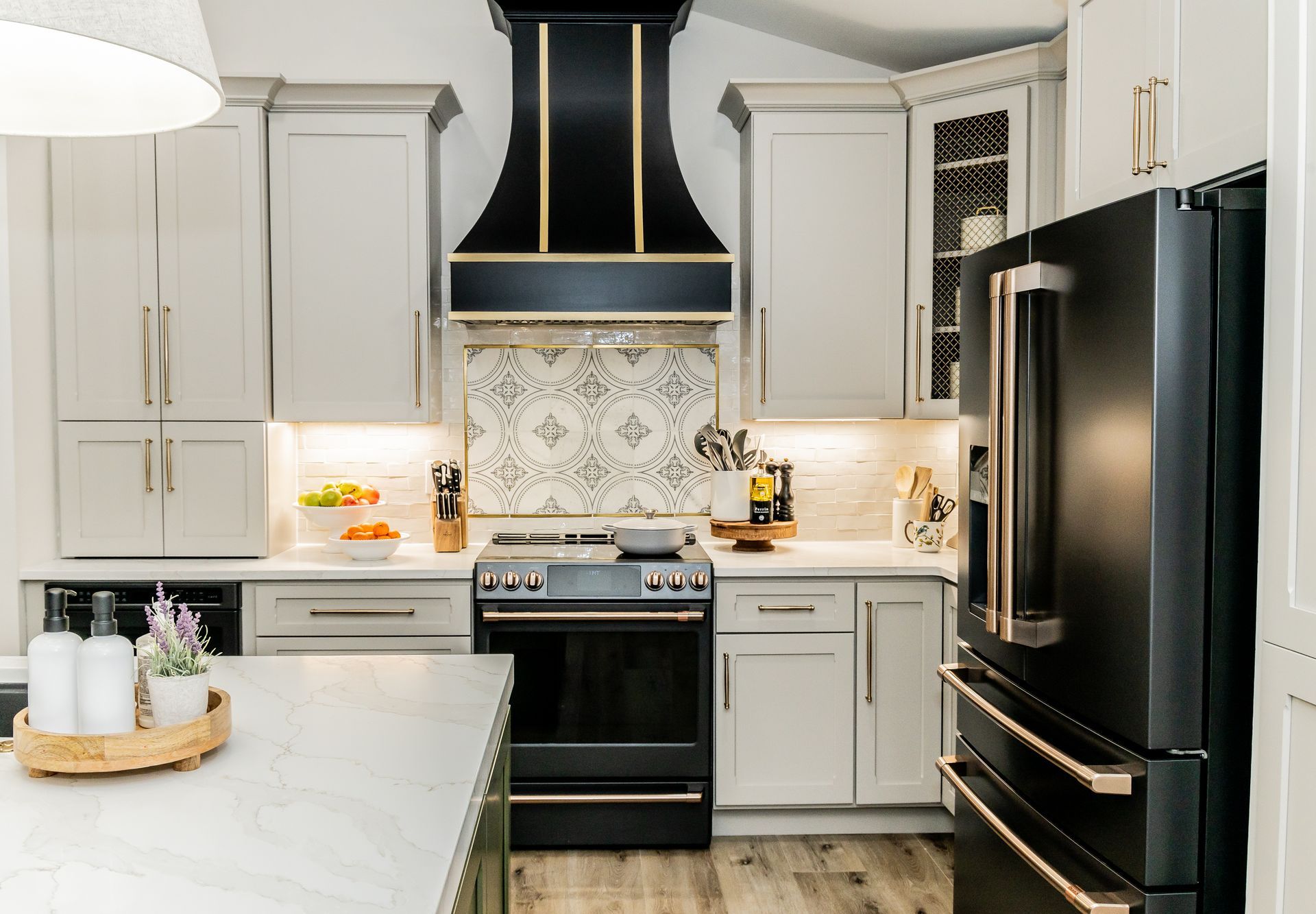 Bright modern kitchen with white cabinets, black range hood, and black refrigerator