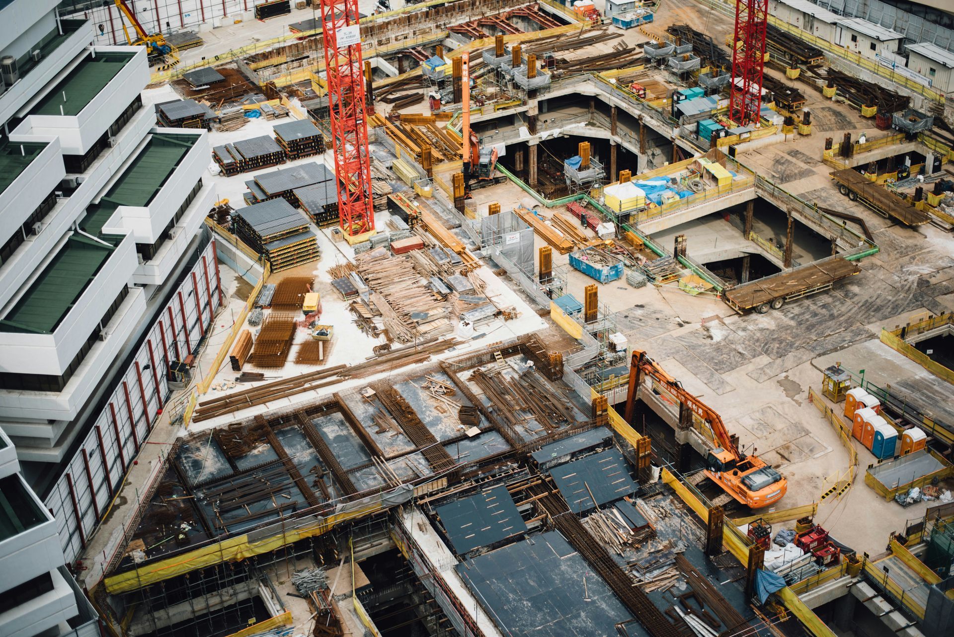 Drone Aerial view of a construction site with cranes, excavators, and concrete foundations.
