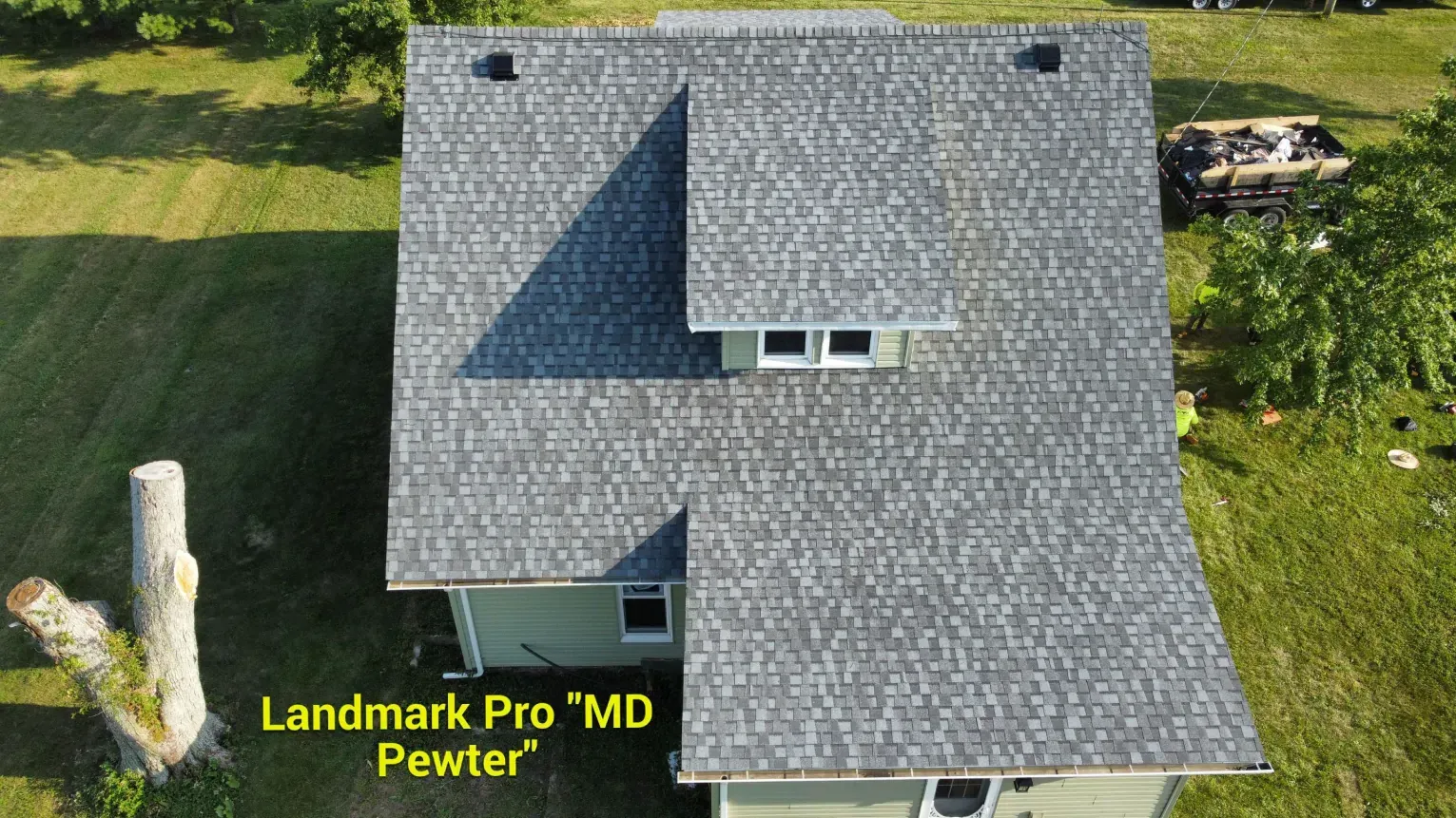 Aerial view of a house roof with grey Landmark Pro Pewter shingles, featuring a central dormer and two roof vents.