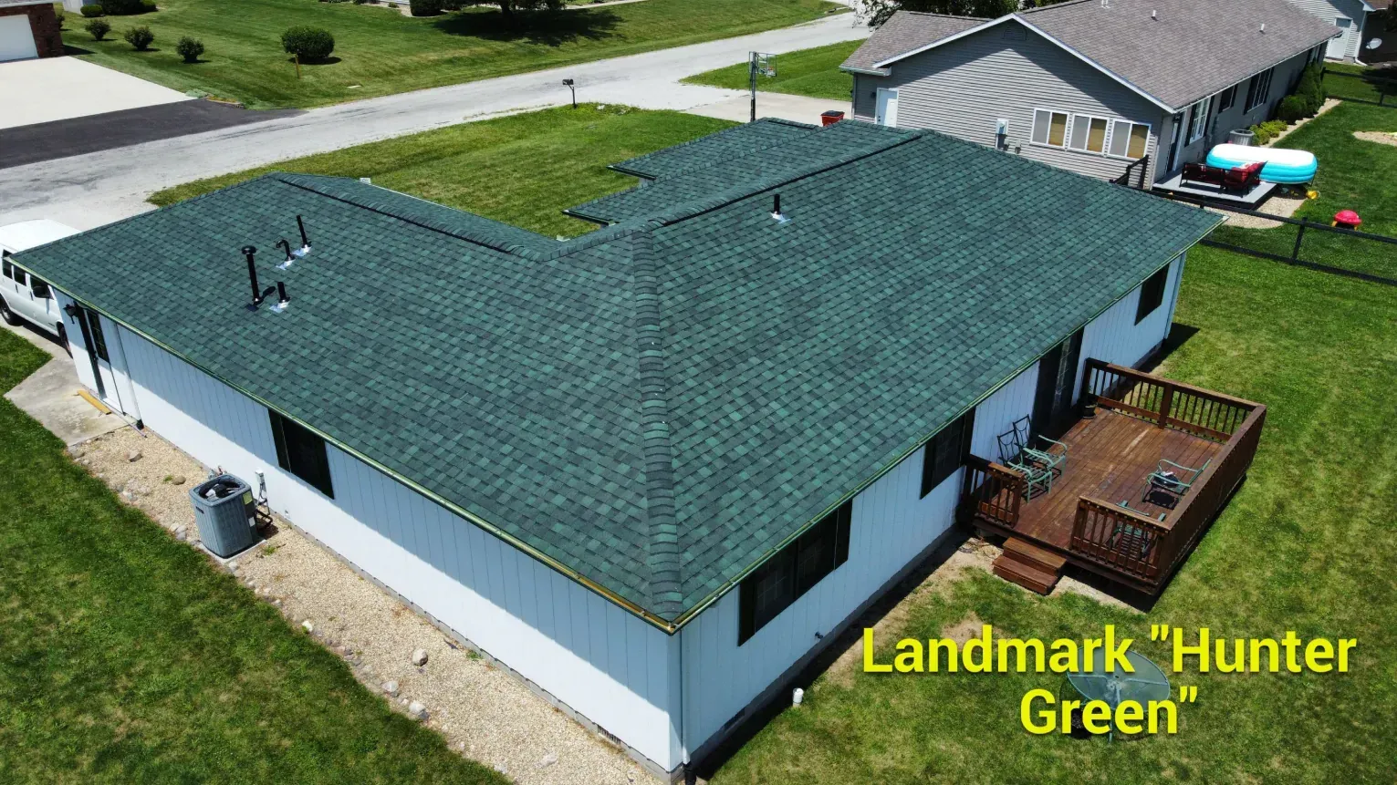 Aerial view of a white L-shaped house with a Landmark 