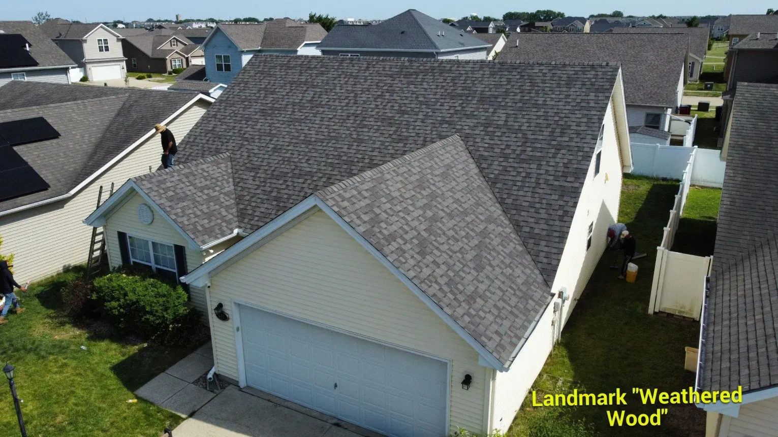 An aerial view of a suburban house featuring a Landmark Weathered Wood shingle roof.