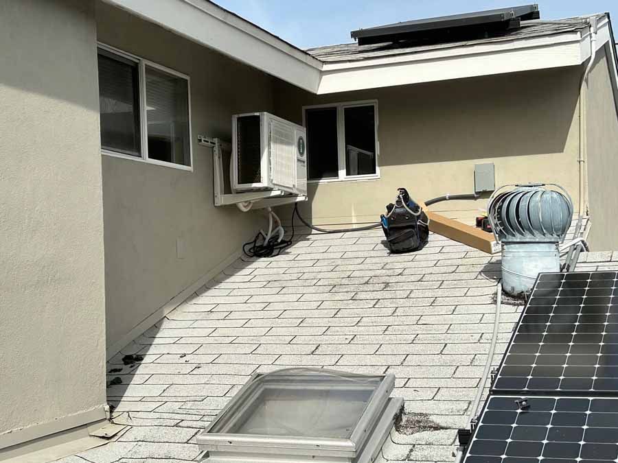 Rooftop with HVAC units, skylight, and solar panels on a flat commercial building