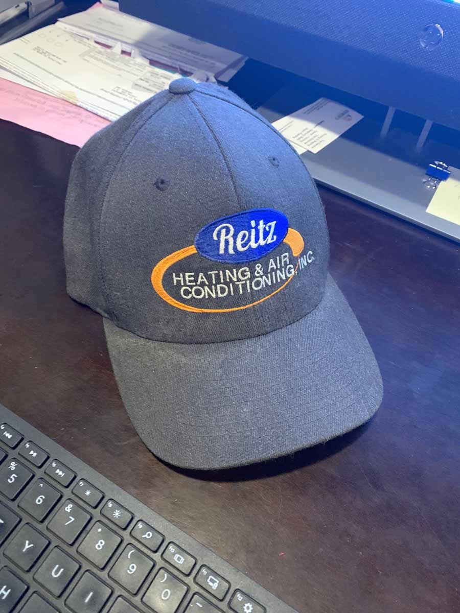 Gray Heilz Heating and Cooling cap on a desk in front of a keyboard
