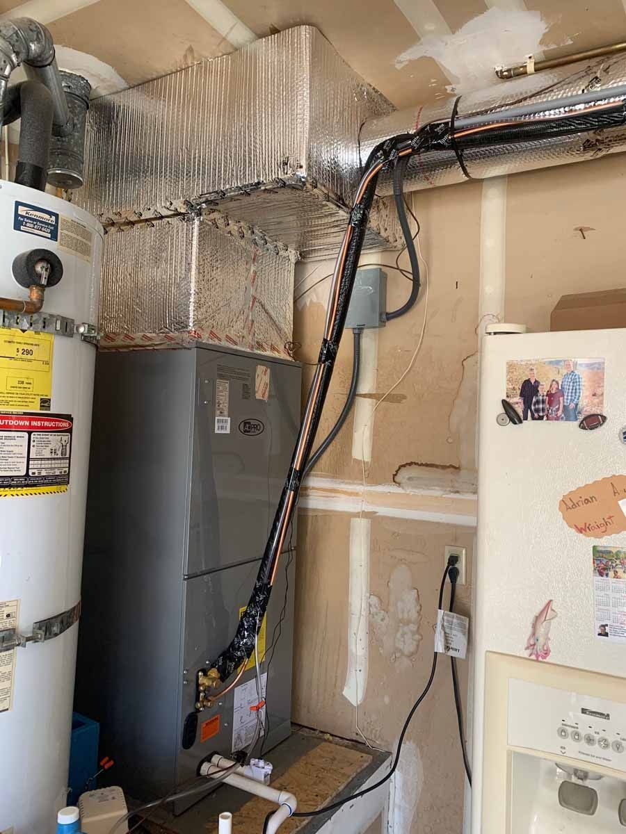 Utility closet with water heater, furnace, and insulated HVAC ducts and pipes.