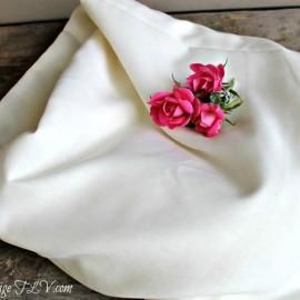 White folded cloth with a small pink rose flower arrangement