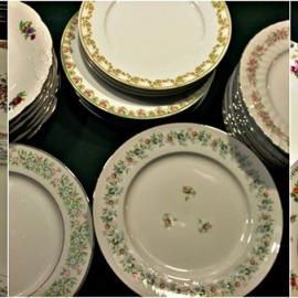 Stacked floral china plates and bowls arranged on a dark surface