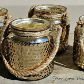 Set of textured gold ceramic mugs with twisted handles on a table