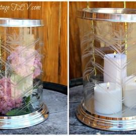 Two silver cylindrical candle holders: one with pink flowers, one with white candles on a tray.