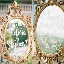Ornate gold framed wedding welcome sign with floral greenery and personalized names, Victoria Stephens and William.