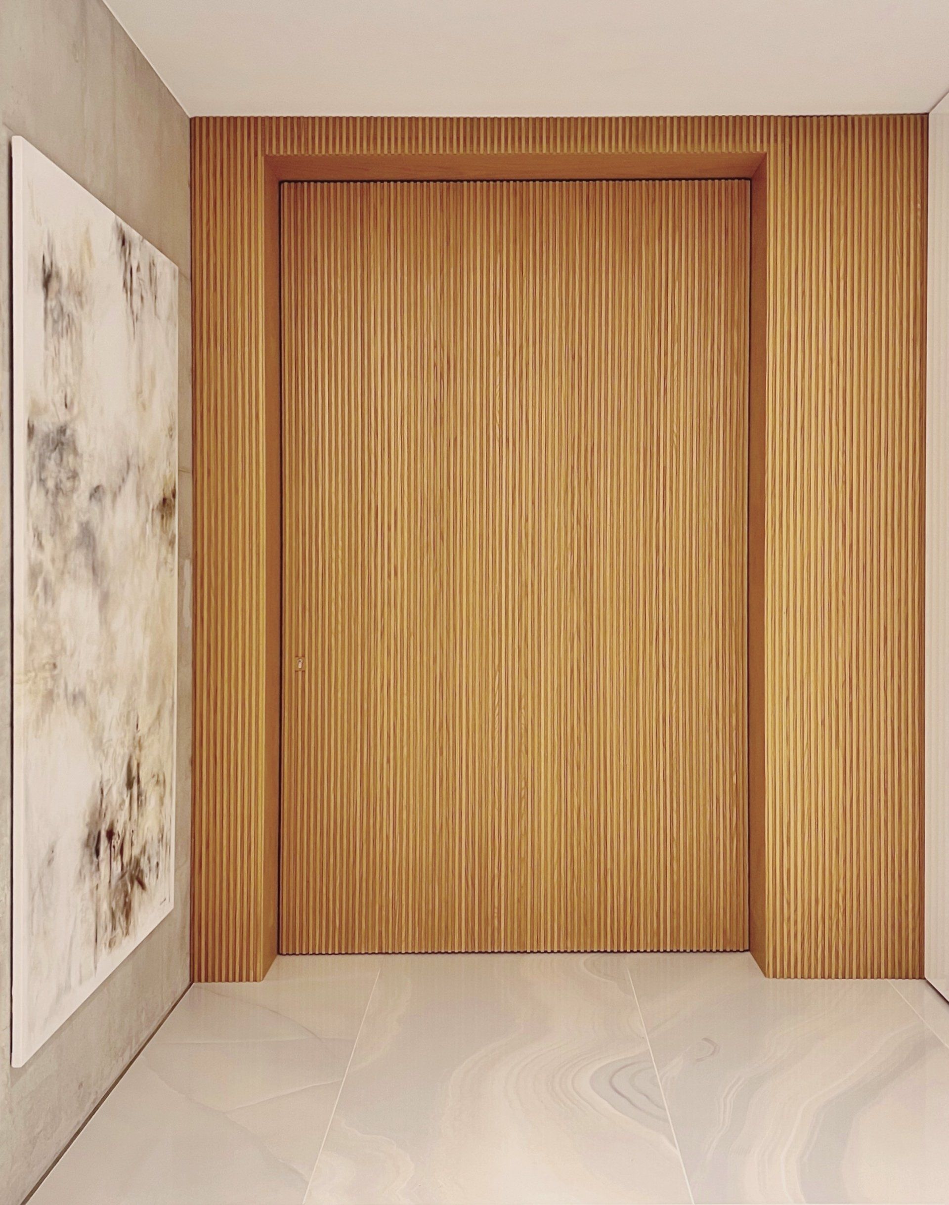 Bespoke timber entrance door with marble wall and brass detailing