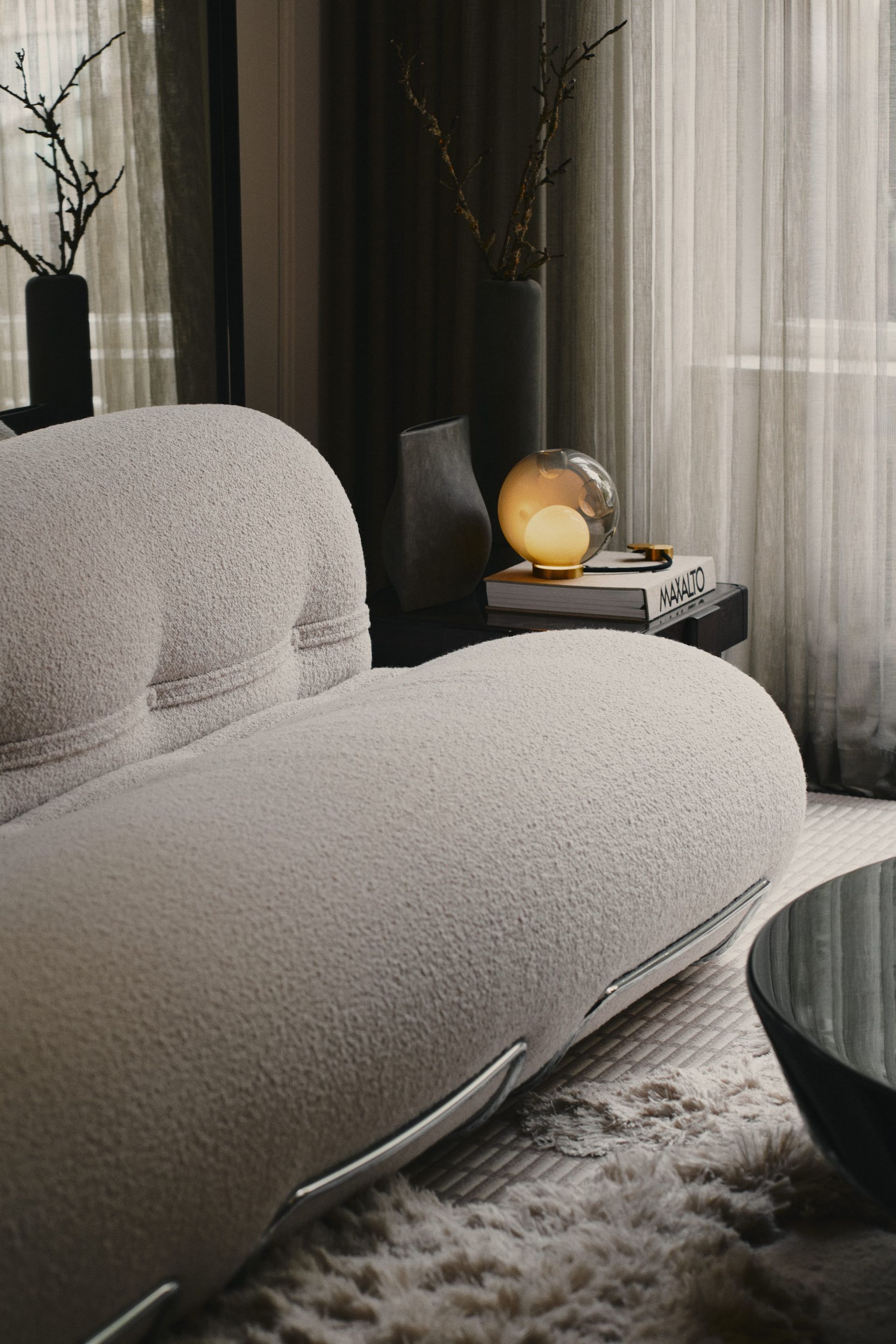 Cream curved sofa and side table at HRS8, the DÉMARTISTUDIO showroom in Berlin