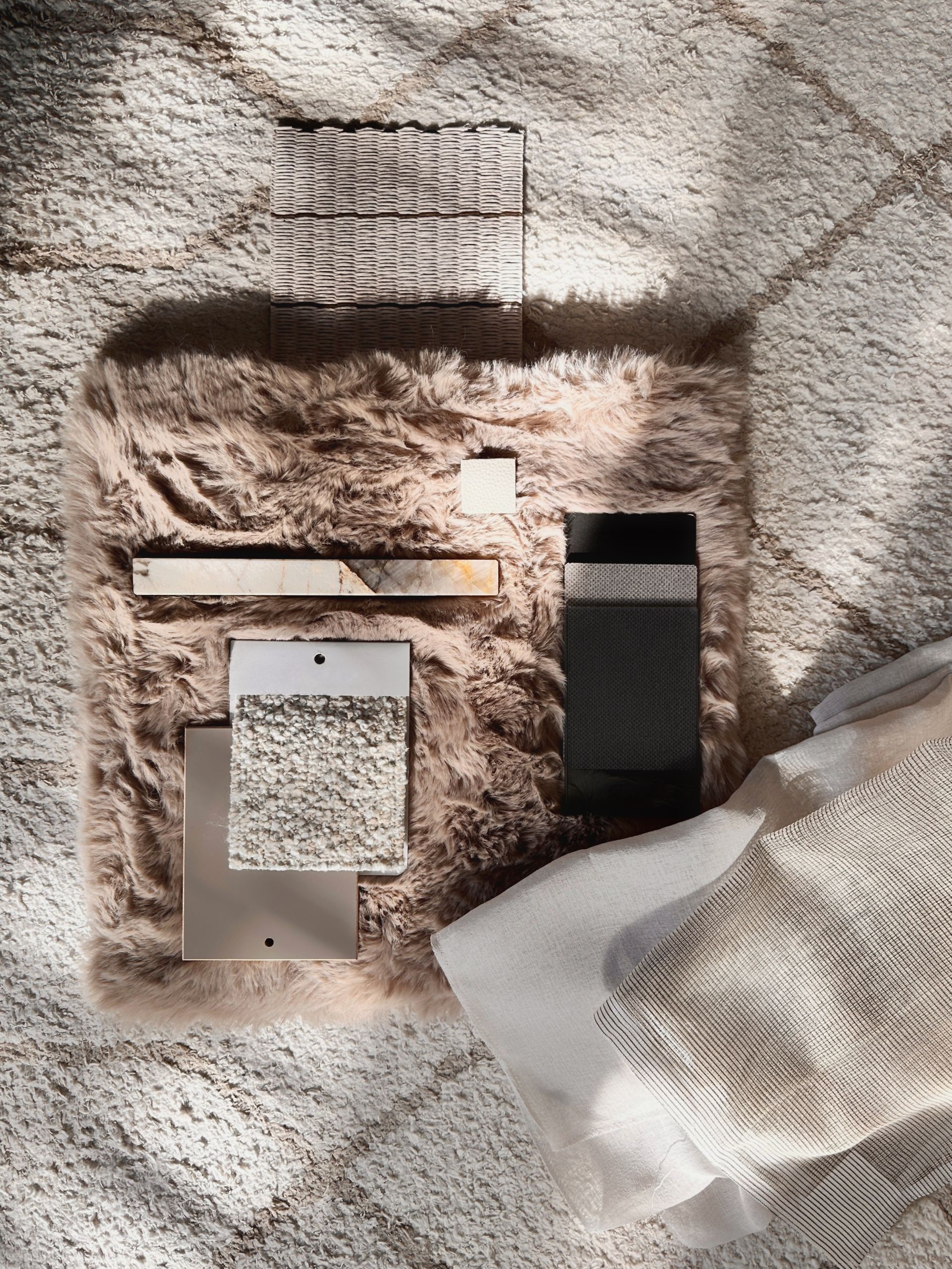 Interior design material moodboard with natural stone, textiles and curated finishes