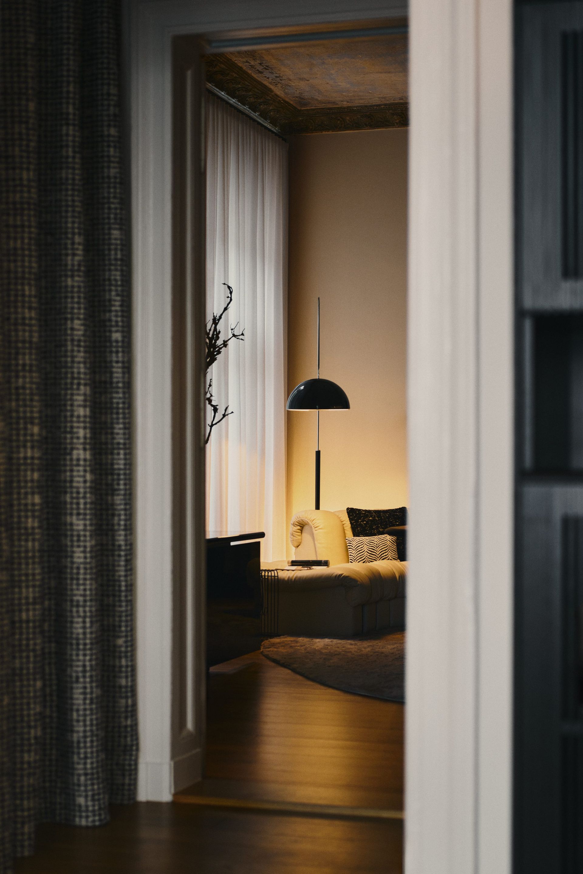 View through a doorway into the softly lit interior of the DÉMARTISTUDIO showroom in Berlin