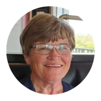 Smiling person wearing glasses, indoors.