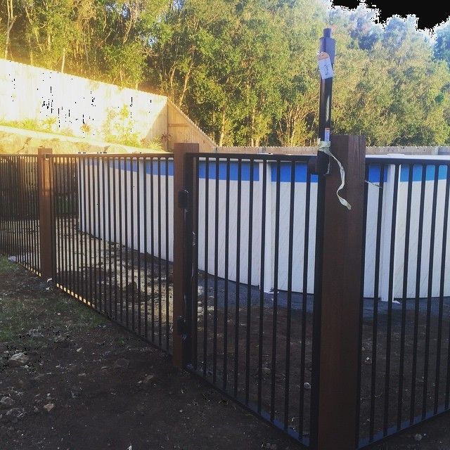 A Metal Fence Surrounds A Swimming Pool — Ballina Best Fencing In Ballina, NSW