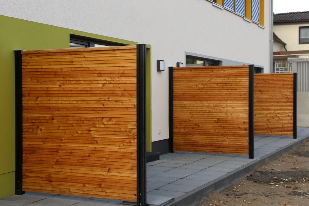 A Row Of Wooden Fences In Front Of A Building — Ballina Best Fencing In Ballina, NSW