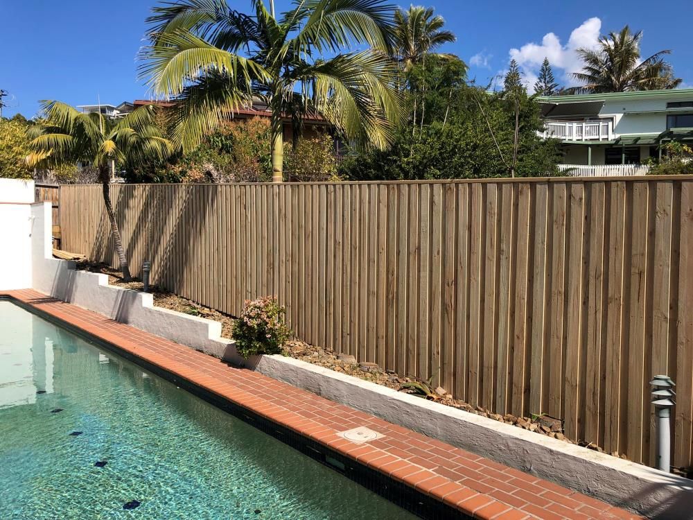 A Wooden Fence Surrounds A Garden In Front Of A House — Ballina Best Fencing In Ballina, NSW