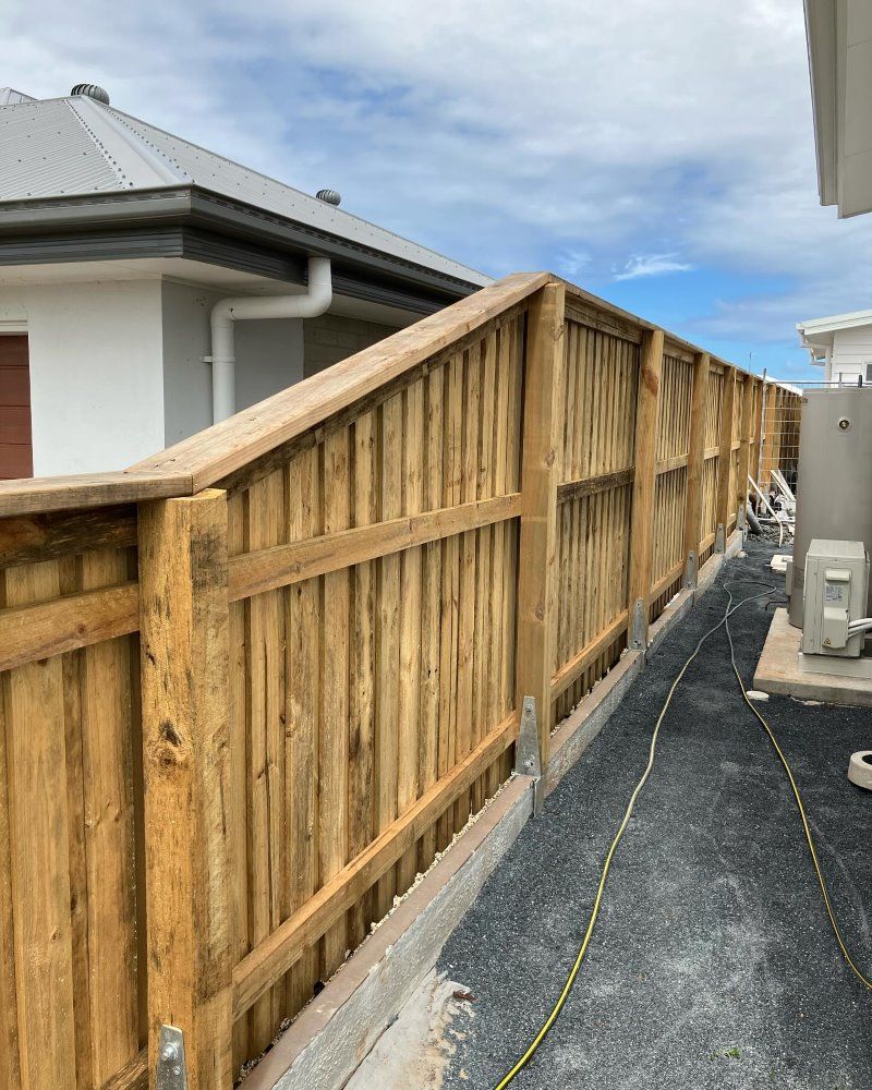 A Wooden Fence Is Being Built In Front Of A House — Ballina Best Fencing In Ballina, NSW