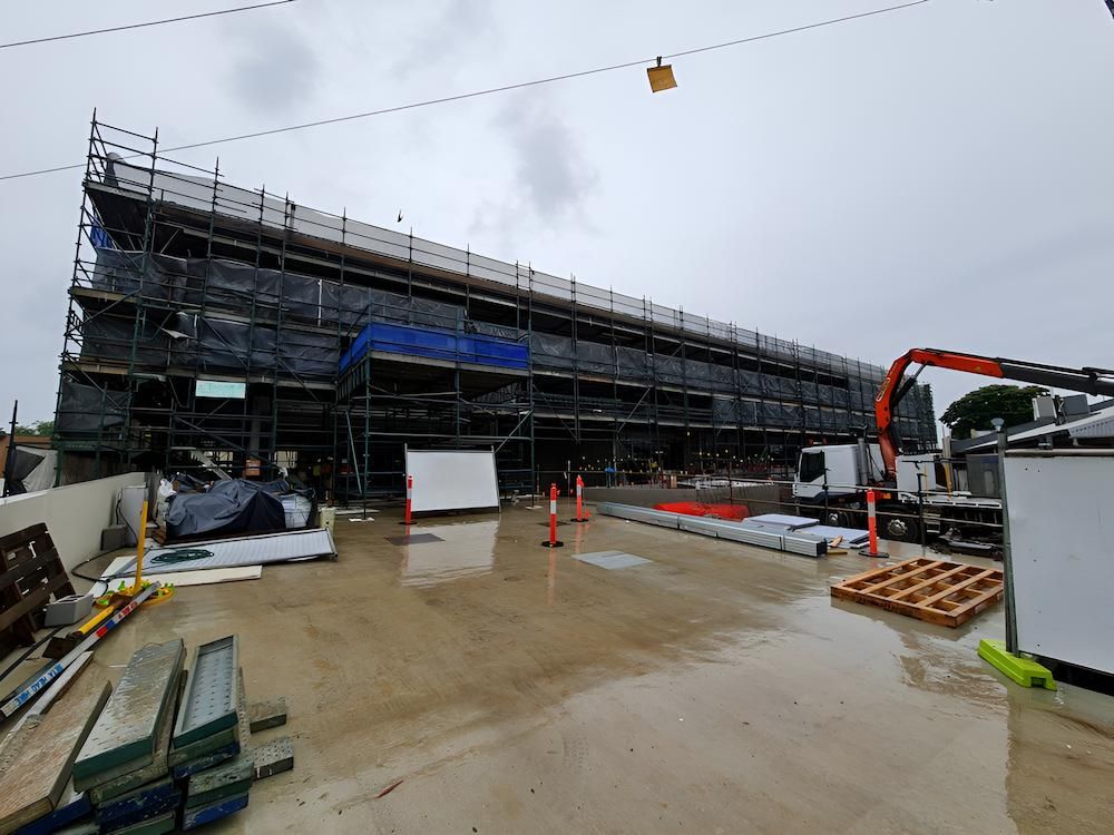 A Large Building Under Construction With Scaffolding and a Crane — All Coast Scaffolding In Yandina, QLD