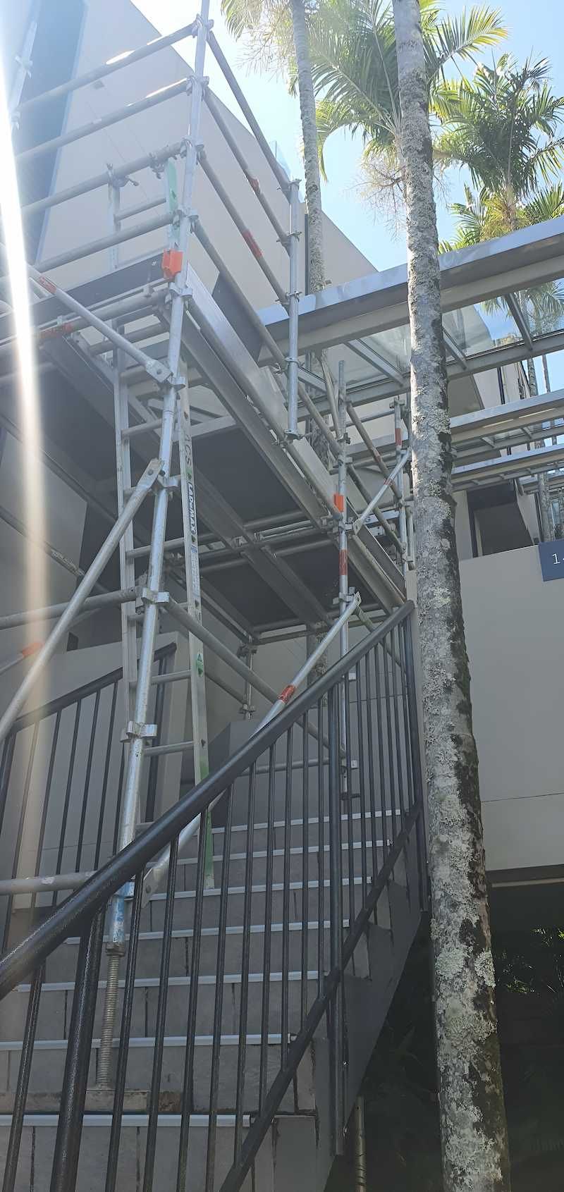 A Staircase With Scaffolding Around It and a Tree in the Background — All Coast Scaffolding In Yandina, QLD