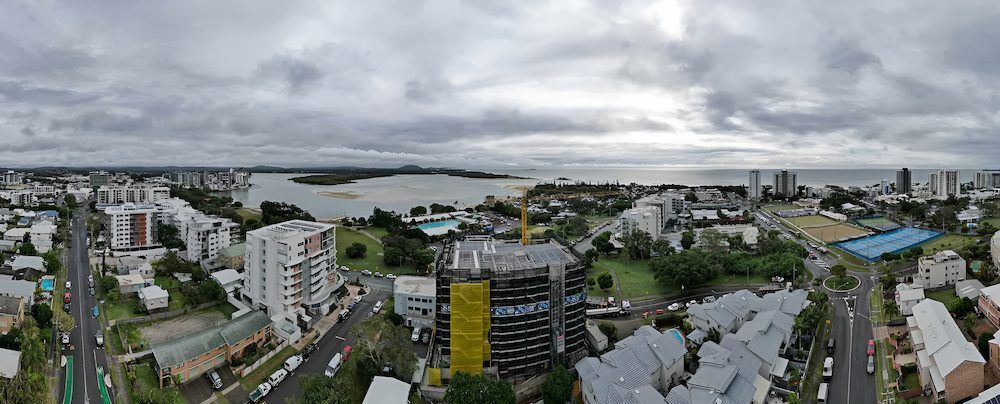 An Aerial View of a City With a Lake in the Background on a Cloudy Day — All Coast Scaffolding In Yandina, QLD