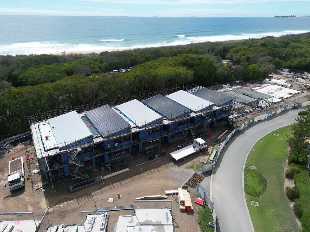 An Aerial View of a Building Under Construction Next to the Ocean — All Coast Scaffolding In Yandina, QLD