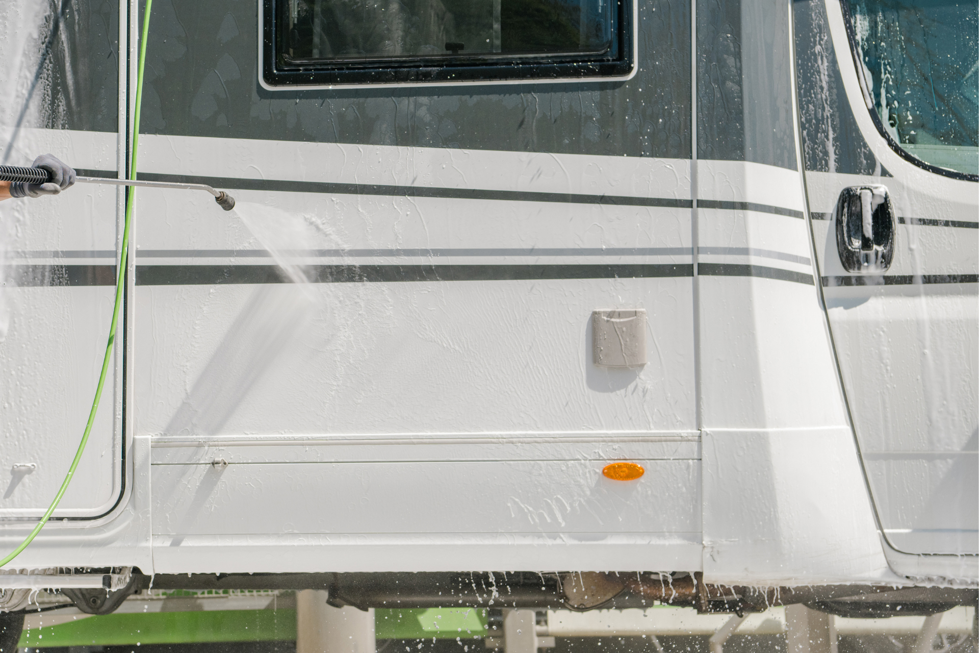 White vehicle side panel with a window, gray stripes, and a small orange reflector.