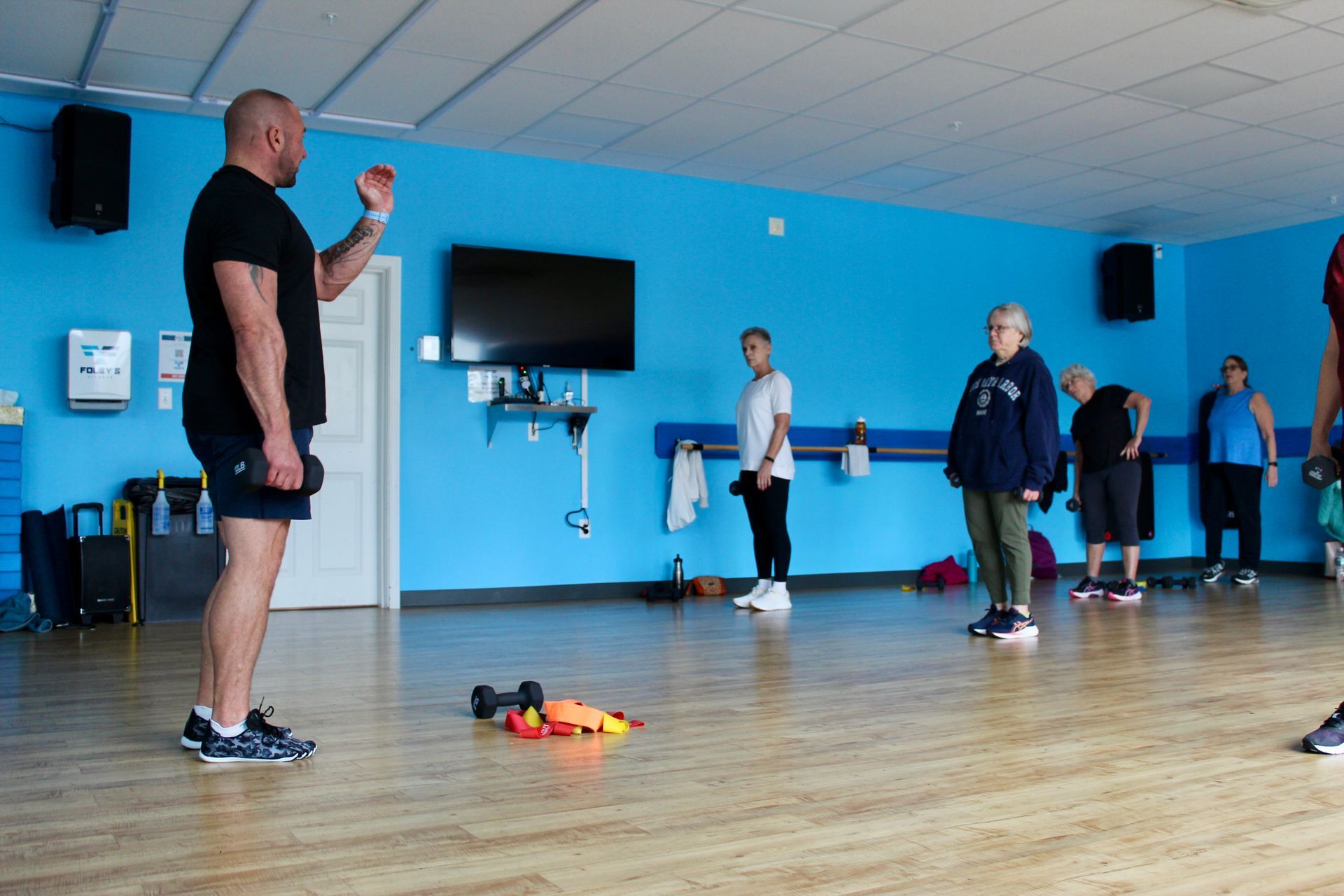 A fitness instructor leading a workout class in a gym.