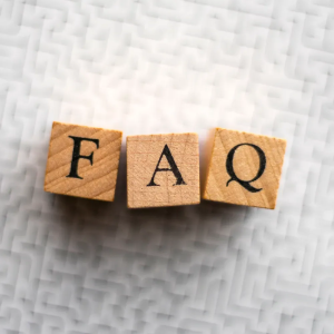 Wooden blocks spelling “FAQ” on a light textured background