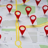 Red location pins on a city map, with highlighted yellow roads and routes.