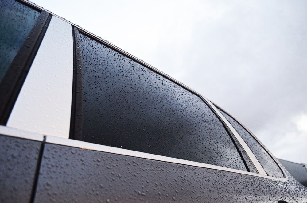 A Close Up of a Car Window With Water Drops on It — Rod's Total Tint In Kurri Kurri, NSW