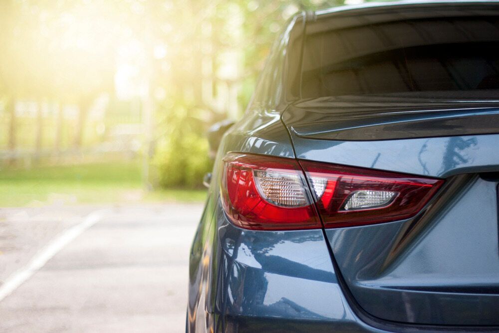 The Back of a Car is Parked on the Side of the Road — Rod's Total Tint In Kurri Kurri, NSW